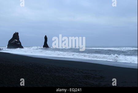 Pile del mare del Nord Oceano Atlantico. spiaggia di sabbia nera sulla costa vicino a vik, Islanda. inverno meteo. Foto Stock