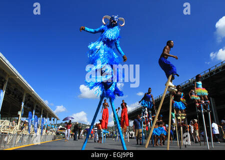 Moko Jumbies danza sulla Queen's Park Savannah stadio durante la Repubblica Banca Carnevale dei Bambini nel porto di Spagna, Trinidad. Foto Stock