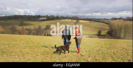 Giovane e il loro cane a spasso per la campagna inglese. Foto Stock