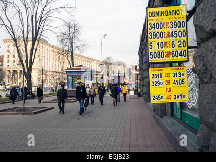 Kiev, Ucraina. Il 25 febbraio, 2015. La gente passa le valute tasso di cambio piastra centro di Kiev. Per l'Ucraina grivna sono crollati più di cento per cento contro il dollaro a un nuovo record basso su Gennaio 6, 2015 dopo la banca centrale ha abbandonato i suoi sforzi per sostenere la valuta. Credito: Igor Golovnov/Alamy Live News Foto Stock