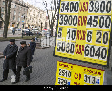 La gente passa le valute tasso di cambio piastra centro di Kiev. Il 25 febbraio, 2015. Per l'Ucraina grivna sono crollati più di cento per cento contro il dollaro a un nuovo record basso su Gennaio 6, 2015 dopo la banca centrale ha abbandonato i suoi sforzi per sostenere la valuta. © Igor Golovniov/ZUMA filo/Alamy Live News Foto Stock