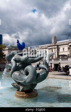 Fontana con Blue galletto scultura al quarto zoccolo in background a Trafalgar Square, Londra Foto Stock