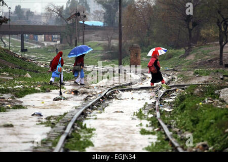 Peshawar. Il 25 febbraio, 2015. Gli studenti pakistani cross inondati di binari ferroviari dopo forti piogge nel nord-ovest del Pakistan Peshawar nel febbraio 25, 2015. Credito: Umar Qayyum/Xinhua/Alamy Live News Foto Stock