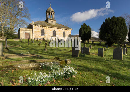 Chiesa di tutti i santi e snowdrops a Brandsby nel North Yorkshire. Foto Stock