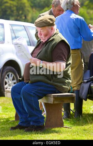 Grande agricoltore leggere il foglietto seduta sul banco di lavoro. Threlkeld mostrano Threlkeld Keswick Lake District Cumbria Inghilterra England Regno Unito Foto Stock