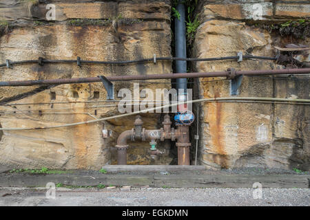 Vecchio arrugginito tubi industriali in una parete. Foto Stock