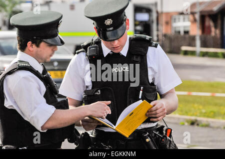 17 maggio 2013, Belfast, Irlanda del Nord. Un PSNI Officer esamina un reato grave scena Log Book (SCSLB), formare 38/15, che registra i movimenti delle forze di polizia e le agenzie partner come arrivano e lasciare a un reato grave scena. Questo può successivamente essere utilizzato in tribunale. Foto Stock