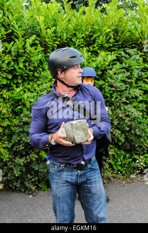 Belfast, Irlanda del Nord. 12 lug 2013 - Ross Kemp solleva un grande pezzo di calcestruzzo che era stata generata durante una sommossa a Belfast Foto Stock