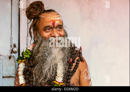 Sadhu, Indù uomo santo, in un pellegrinaggio che indossa la faccia delle marcature e collane di perle. Foto Stock