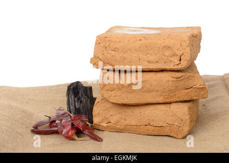 Meju (di soia fermentati) forfettaria e ingredienti di base per rendere doenjang, isolato su bianco. Foto Stock