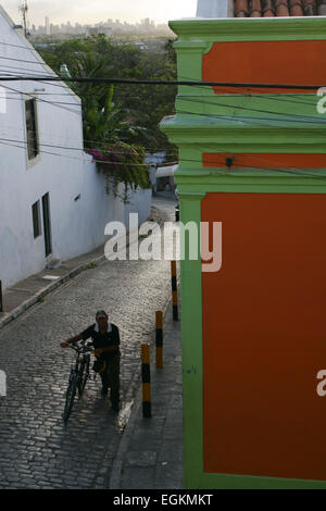 Ciclista spingendo bike up steep hill in Olinda, Brasile Foto Stock