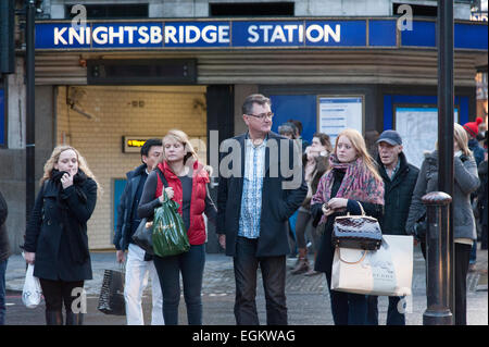 Gli amanti dello shopping attraversando la strada al di fuori di stazione metro di Knightsbridge di Londra. Foto Stock