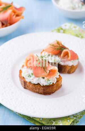 Crostino con salmone affumicato e crema di formaggio sulla piastra, il fuoco selettivo Foto Stock