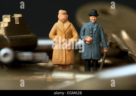 Una coppia di miniatura modello in scala le figure in piedi tra un mucchio di chiavi. Foto Stock