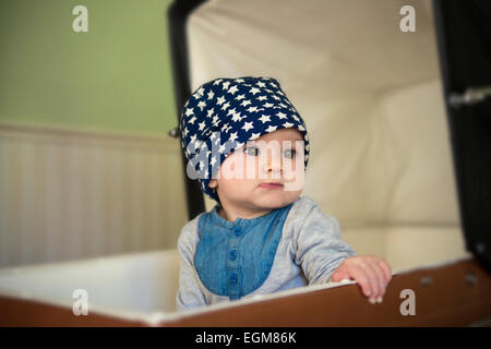 Bellissimo bambino guardando sopra la spalla seduta in un passeggino rétro Foto Stock