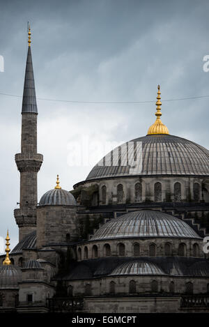 ISTANBUL, Turchia — le cupole della Moschea Blu di Istanbul contro un cielo nuvoloso. Mentre è ampiamente conosciuta come la Moschea Blu per le sue piastrelle interne, il nome formale della moschea è Sultan Ahmed Mosque (o Sultan Ahmet Camii in turco). Fu costruito dal 1609 al 1616 durante il dominio del sultano Ahmed I. Foto Stock
