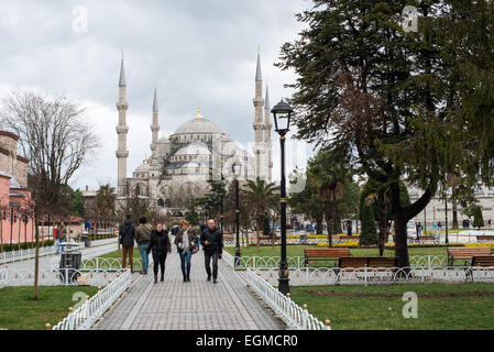 ISTANBUL, Turchia: I turisti camminano attraverso Piazza Sultanahmet, la storica piazza tra la Moschea del Sultano Ahmed (Moschea Blu) e Santa Sofia. Questo spazio funge da cuore del quartiere storico di Istanbul, collegando due dei monumenti religiosi più significativi della città. La piazza segna il punto centrale dell'area patrimonio dell'umanità dell'UNESCO di Istanbul. Foto Stock