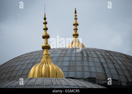 ISTANBUL, Turchia - le punte dorate coronano le cupole di Santa Sofia, aggiunte durante il periodo ottomano come parte della conversione dell'edificio in moschea. Questi elementi architettonici combinano funzioni decorative e religiose. La lavorazione dei metalli dimostra elementi caratteristici dell'architettura della moschea ottomana. Foto Stock