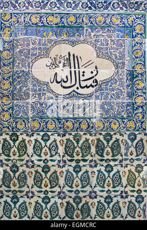 ISTANBUL, Turchia / Türkiye - squisite piastrelle Iznik adornano le pareti della Moschea Harem (Harem Mescidi) nel Palazzo Topkapi, Istanbul. Questi capolavori ceramici del XVII secolo, caratterizzati da intricati motivi floreali e calligrafia in vibranti blu, verdi e rossi, esemplificano il pinnacolo delle arti decorative ottomane all'interno di questo spazio di preghiera privato per le donne più importanti dell'harem imperiale. Foto Stock