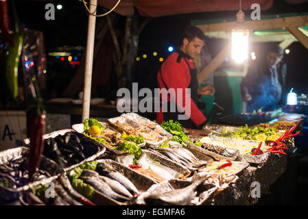 Venditori di Grigliata di Pesce Fresco Karakoy Istanbul | ISTANBUL, Turchia — Venditori che grigliano pesce fresco al mercato del pesce di Karaköy sul lungofiume del Corno d'Oro, appena a nord-ovest del ponte di Galata vicino ai moli dei traghetti di Karaköy. Conosciuto localmente come Karaköy Balıkçılar Çarşısı, il mercato fa risalire le sue origini a circa il 1940 e da lungo tempo attira pescivendoli che vendono cacciure provenienti da tutta la Turchia. Le bancarelle visibili qui facevano parte della fila informale lungo la riva che la municipalità metropolitana di Istanbul ha sgomberato e sostituito con un edificio di mercato chiuso alla fine del 2015. Foto Stock
