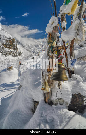 Campana buddista e bandiere di preghiera in Himalaya vicino Kangchendzonga, il terzo più alto di montagna del mondo Foto Stock