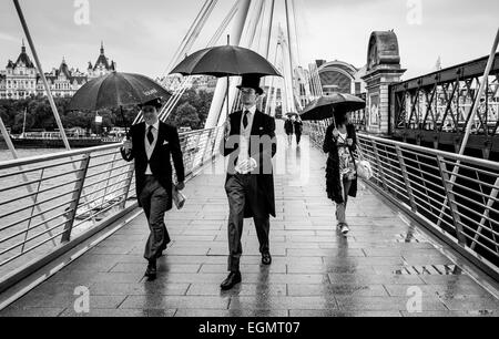 Due uomini indossando il tradizionale Top Hat e code sul loro modo di Ascot per una giornata di gare, il Golden Jubilee Bridges, Londra Foto Stock