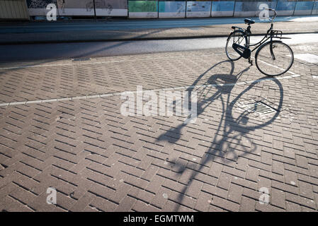 Una bicicletta olandese parcheggiato in silhouette su una strada ad Amsterdam, Olanda Foto Stock