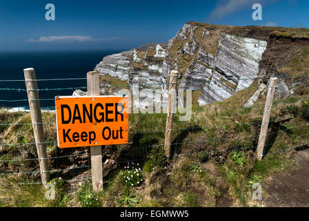 Segnale di avvertimento sul bordo delle scogliere alte nella Contea di Kerry, Repubblica di Irlanda Foto Stock
