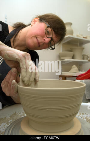 La ceramica tutor presso un adulto learning center dimostrando gettando sulla ruota di ceramiche, Surrey, Regno Unito. Foto Stock