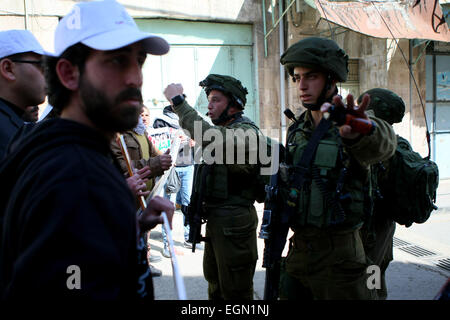 Hebron, West Bank, Territorio palestinese. Il 27 febbraio, 2015. Soldati israeliani sostengono con dimostranti palestinesi durante una manifestazione di protesta chiedendo la riapertura di Shuhada Street in Cisgiordania città di Hebron il 27 febbraio 2015 © Mamoun Wazwaz APA/images/ZUMA filo/Alamy Live News Foto Stock