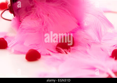 Il giorno di San Valentino decorazioni, piume rosa a forma di cuore caramelle Foto Stock