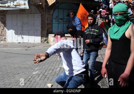 Hebron, West Bank. Il 27 febbraio, 2015. I dimostranti palestinesi lanciare sassi verso i soldati israeliani durante scontri in una protesta chiedendo la riapertura di Shuhada Street in Cisgiordania città di Hebron. © Mamoun Wazwaz APA/images/ZUMA filo/Alamy Live News Foto Stock