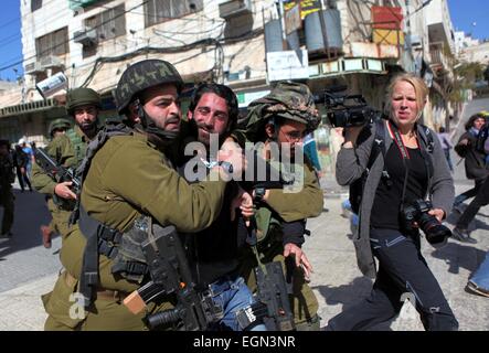 Hebron, West Bank. Il 27 febbraio, 2015. Soldati israeliani arrestare un dimostrante palestinese durante una manifestazione di protesta chiedendo la riapertura di Shuhada Street in Cisgiordania città di Hebron. © Mamoun Wazwaz APA/images/ZUMA filo/Alamy Live News Foto Stock