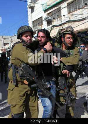 Hebron, West Bank. Il 27 febbraio, 2015. Soldati israeliani arrestare un dimostrante palestinese durante una manifestazione di protesta chiedendo la riapertura di Shuhada Street in Cisgiordania città di Hebron. © Mamoun Wazwaz APA/images/ZUMA filo/Alamy Live News Foto Stock