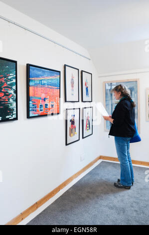 Donna che guarda ad una mostra nella galleria Loft, St Margaret speranza, South Ronaldsay, Orkney Islands, Scozia. Foto Stock