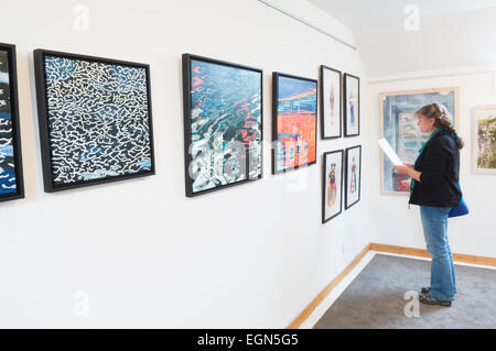 Donna che guarda ad una mostra nella galleria Loft, St Margaret speranza, South Ronaldsay, Orkney Islands, Scozia. Foto Stock