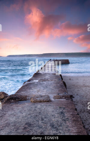 Tramonto spettacolare cielo sopra il molo Sennen Cove nel lontano ovest della Cornovaglia Foto Stock