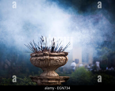 Bastoncini di incenso bruciare davanti al tempio del Dente, Kandy, Sri Lanka Foto Stock