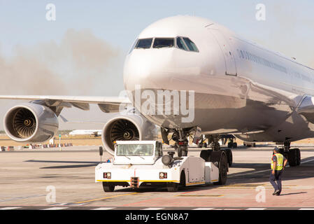 Jet del passeggero trainato da un rimorchiatore al aeroporto di pista di rullaggio Foto Stock