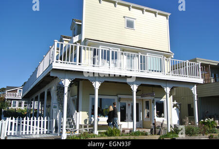 Shopper turistiche a piedi lungo la strada principale con il vecchio magazzino vittoriano fronti nel centro storico di Mendocino in California del Nord Foto Stock