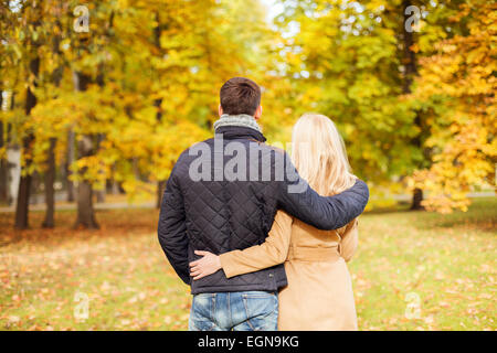 Giovane costeggiata in autunno park dal retro Foto Stock