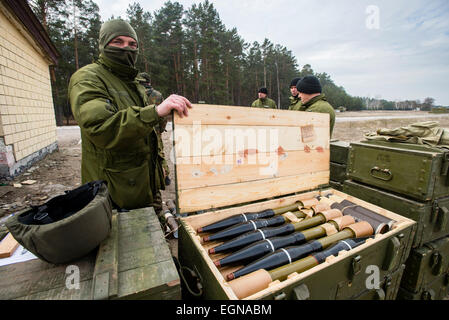 Soldato che mostra di razzi per SPG recoilless gun utilizzando per la cottura di formazione con SPG recoilless pistole e fucili Kalashnikov al 169a centro di formazione di suolo ucraino forze militari più grande formazione formazione in Ucraina, a Desna chiuso città di cantonment, Ucraina. Il 25 di febbraio. Foto di Oleksandr Rupeta Foto Stock