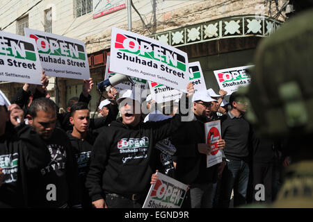 Hebron. Il 27 febbraio, 2015. I dimostranti palestinesi tenere banner come essi prendono parte in una protesta chiamando per l'apertura della al-Shuhada Street e la fine di Israele la professione, in Cisgiordania città di Hebron il 27 febbraio 2015. © Mamoun Wazwaz/Xinhua/Alamy Live News Foto Stock