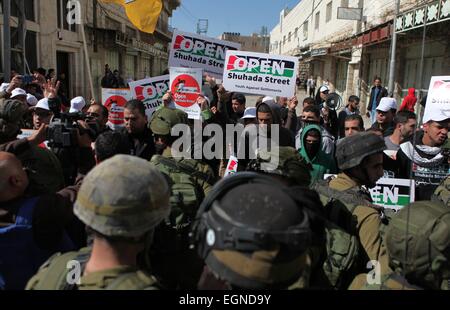 Hebron. Il 27 febbraio, 2015. I dimostranti palestinesi tenere banner come essi prendono parte in una protesta chiamando per l'apertura della al-Shuhada Street e la fine di Israele la professione, in Cisgiordania città di Hebron il 27 febbraio 2015. © Mamoun Wazwaz/Xinhua/Alamy Live News Foto Stock