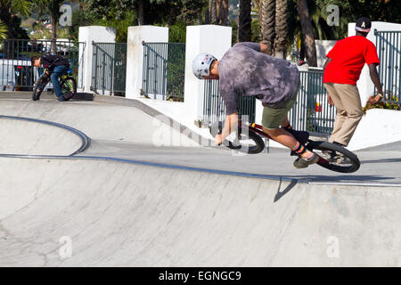 Un ragazzo facendo un salto acrobatico sulla sua moto a skate park a Santa Barbara, California. Foto Stock