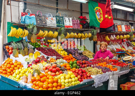 Porto, Portogallo. Venditore di frutta di organizzazione e di prendersi cura di supporto all'interno dello storico mercato Bolhao Foto Stock