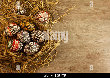 Uova di Pasqua nel nido su sfondo di legno Foto Stock