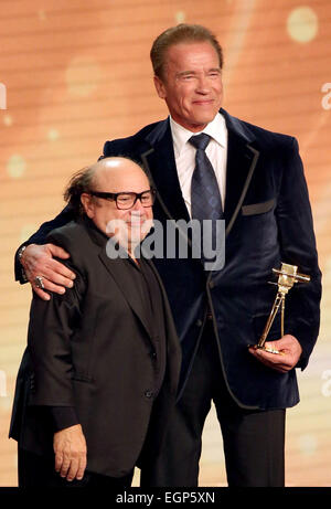 Amburgo, Germania. Il 27 febbraio, 2015. Noi attore Danny DeVito (l) mani "Goldene Kamera' aggiudicazione di Arnold Schwarzenegger durante il cinquantesimo Golden Fotocamera (Premio Goldene Kamera) cerimonia in Amburgo, Germania, 27 febbraio 2015. Schwarzenegger è stato onorato per la sua vita di lavoro. Foto: Christian Charisius/dpa/Alamy Live News Foto Stock