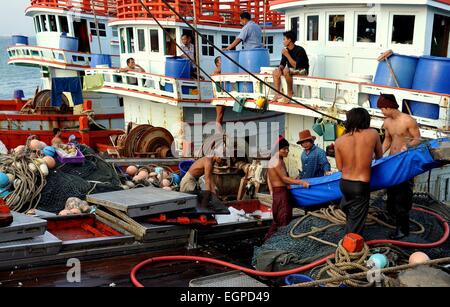 Hua Hin, Thailandia: pescherecci membri dell equipaggio caricamento di ghiaccio in attesa della loro nave ormeggiata in Hua Hin Pier di pesca Foto Stock