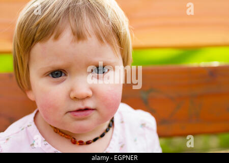 Ritratto di un anno di età ragazza in un parco con luce naturale. Foto Stock